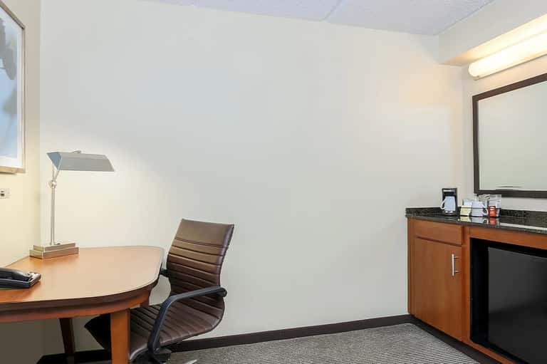 Hotel consultation room with desk, chair, mirror, and professional lighting
