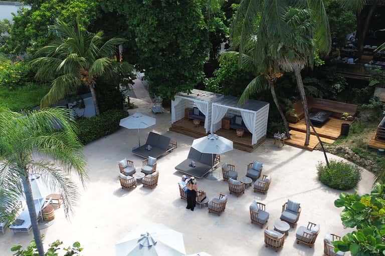 Overhead view of tropical resort courtyard with lounge chairs and white umbrellas