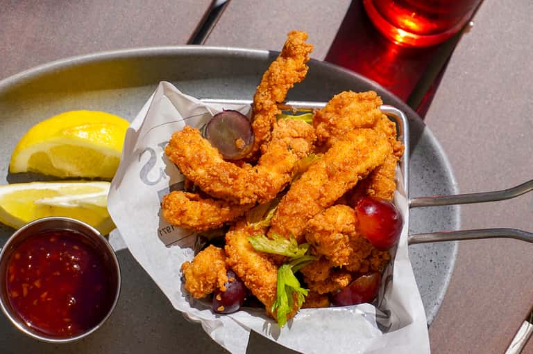 Fried shrimp served with lemon wedges and dipping sauce on a plate