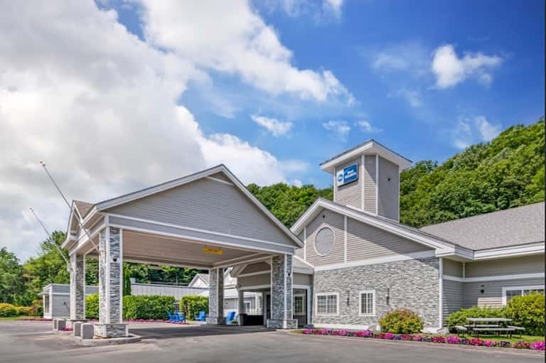 Hotel entrance with covered portico, stone accents, and manicured landscaping