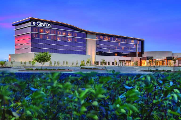 Contemporary Graton Hotel exterior at dusk with illuminated windows and manicured landscaping