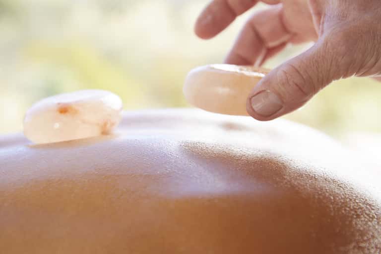 Close-up of sunscreen being applied to sun-kissed skin on shoulder