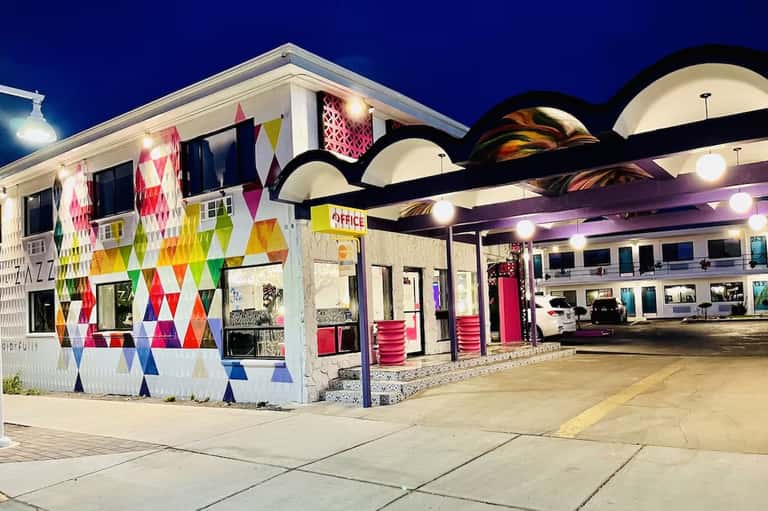 Colorful motel office with geometric diamond pattern facade at night