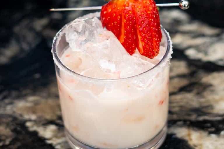 Strawberry garnish on frozen cocktail with ice, close-up shot