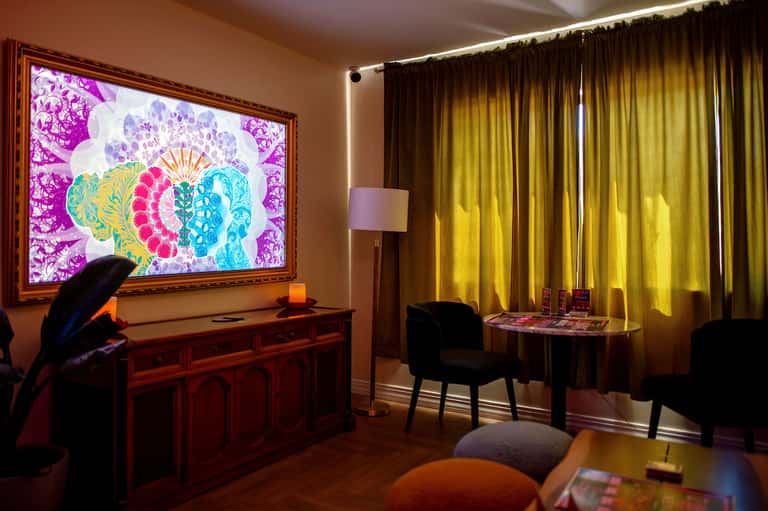 Elegant entertainment room with colorful digital artwork display and golden curtains