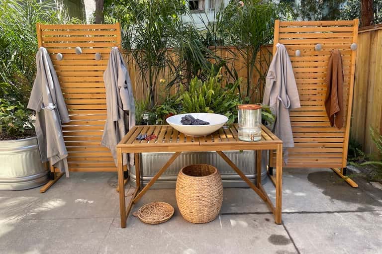 Wooden lounge chairs and table with towels in a tropical garden patio setting