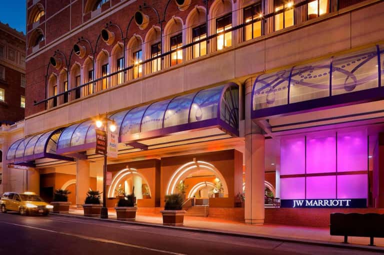JW Marriott hotel entrance at night with illuminated orange archways and pink signage