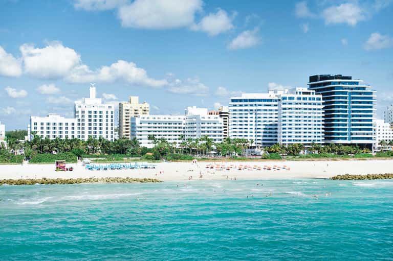 High-rise beachfront hotels along Miami beach with turquoise ocean and sandy shore