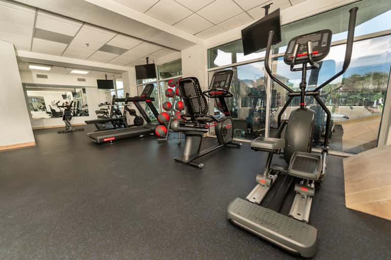 Modern fitness center with cardio equipment, exercise bikes, treadmills, and large windows overlooking mountains