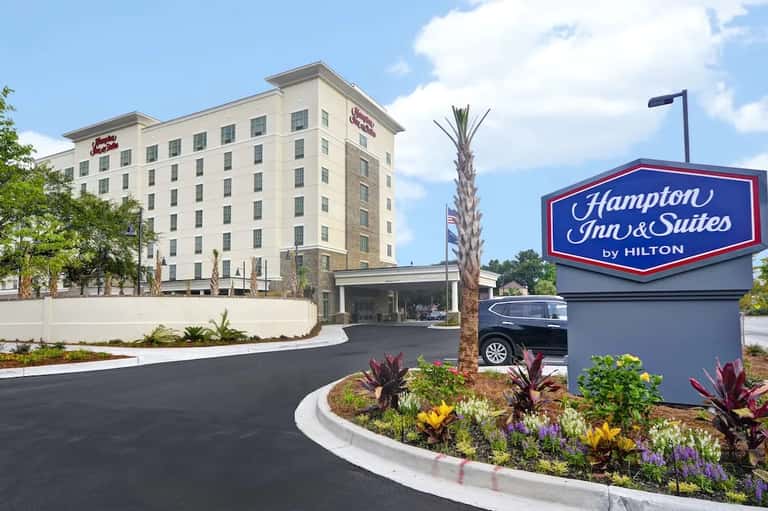 Hampton Inn & Suites hotel exterior with entrance, signage, and landscaped grounds