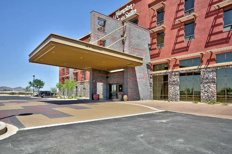 Historic hotel building exterior with red brick, stone accents, and modern porte-cochere entrance