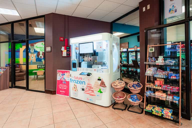 Hotel convenience area with ice cream vending machine, colorful merchandise shelves, and small retail space