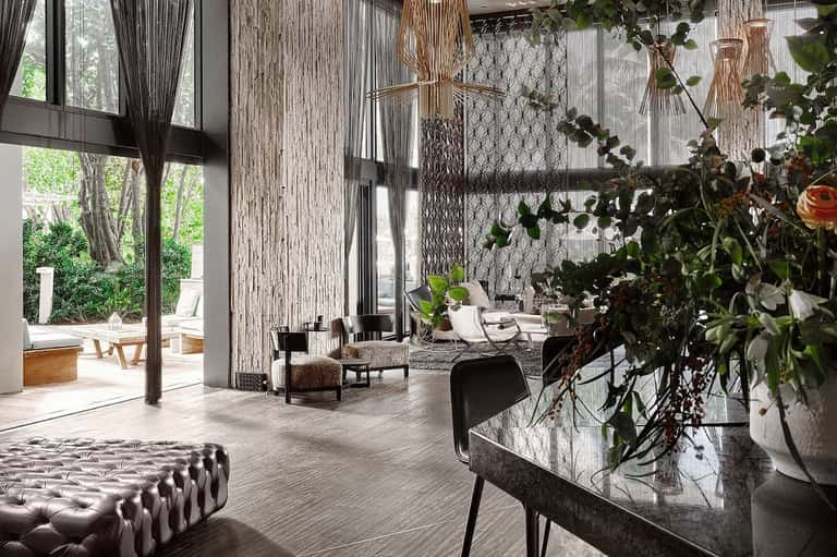 Modern spa lobby with floor-to-ceiling windows, hanging plants, and contemporary furnishings