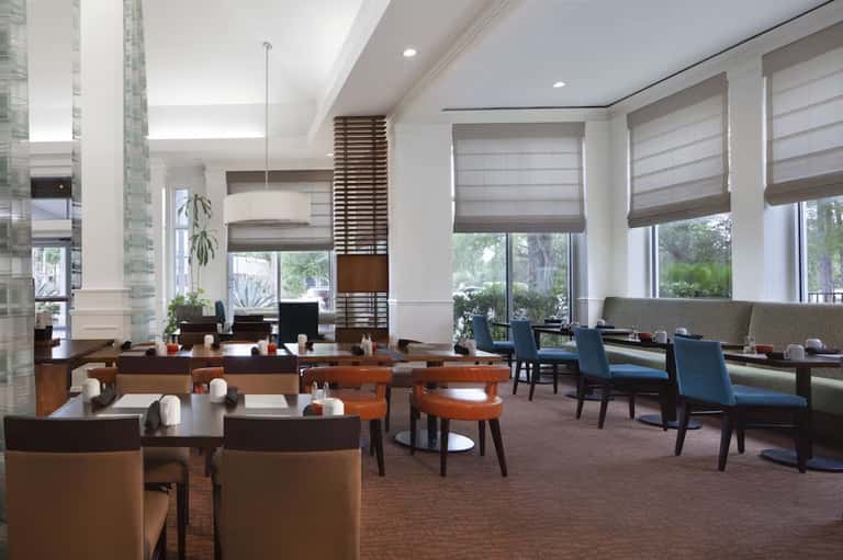 Contemporary hotel lounge with brown leather seating, wood accents, and large windows