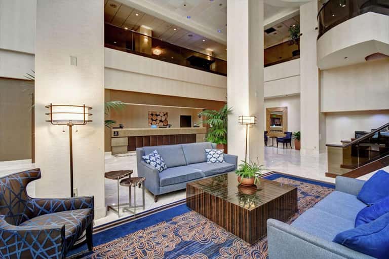 Spacious hotel lobby with high ceilings, blue sofas, and contemporary furnishings