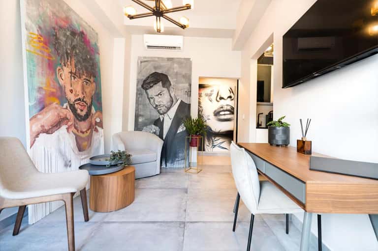 Contemporary hotel suite with colorful pop art on walls, living area, and kitchen