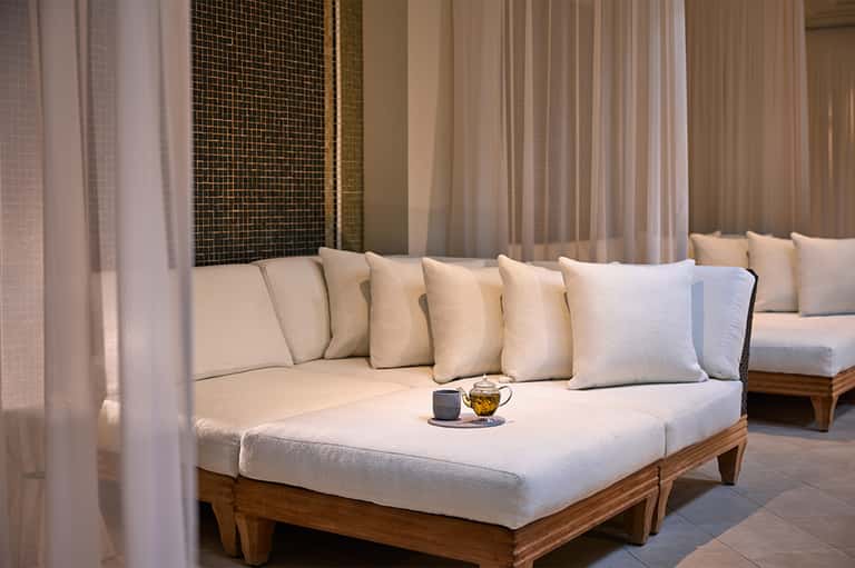 Luxury spa relaxation lounge with cream daybed and sheer curtains