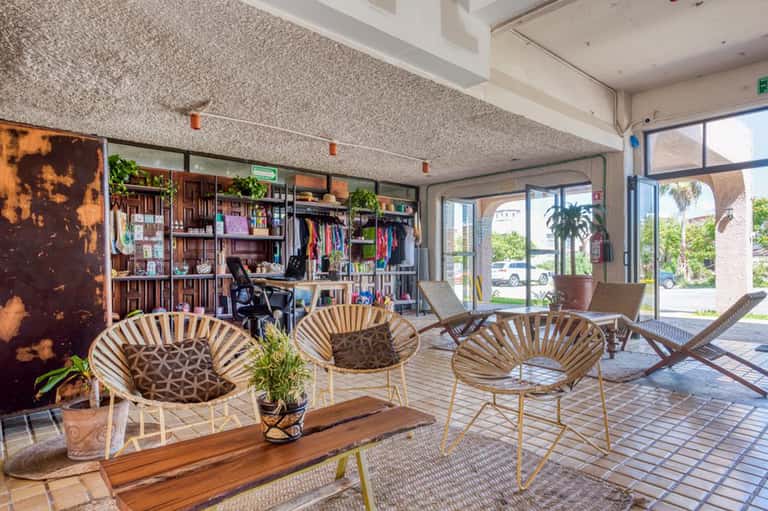 Modern hotel lobby with mid-century chairs, retail shelving, and large windows