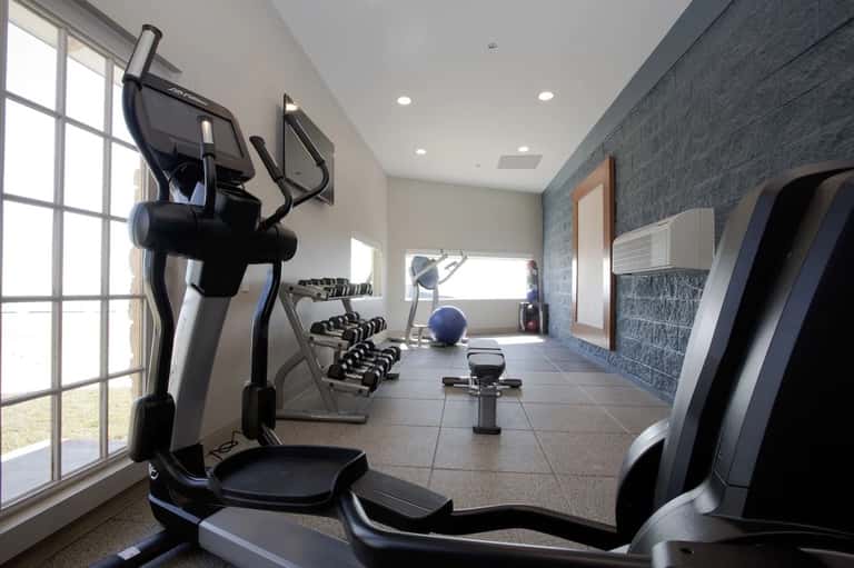Modern fitness center with elliptical machines and dumbbells