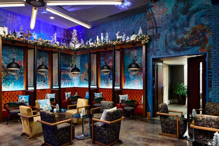 Elegant lounge area with blue brick walls, holiday decorations, and upholstered seating