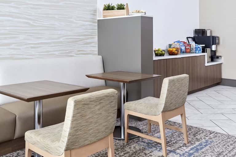 Contemporary cafe interior with wooden tables, upholstered chairs, and service counter