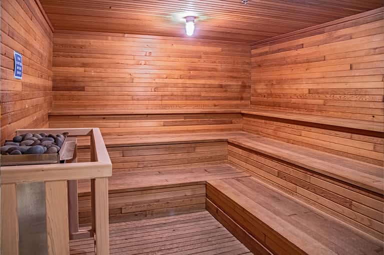Wooden sauna interior with tiered benches and stone heater