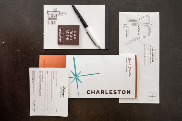 Charleston hotel branding materials including maps, sketches, and design guides on dark surface