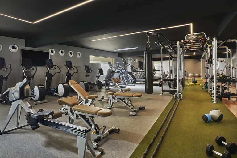 Modern fitness center with exercise equipment, cardio machines, and functional training area