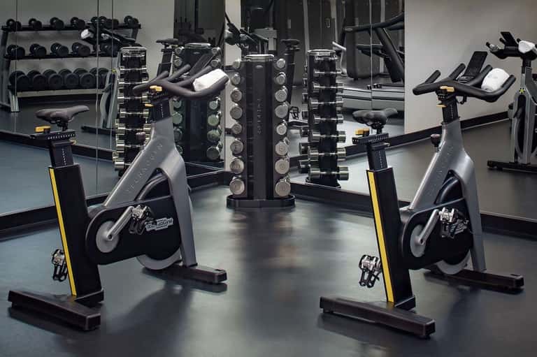 Fitness center with stationary bikes, dumbbells on racks, and exercise equipment
