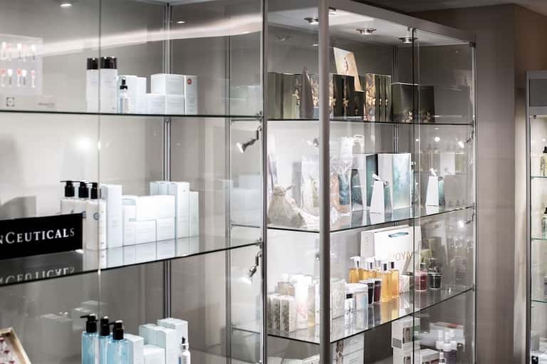 Spa retail display with glass shelving and metal frames showcasing skincare and beauty products