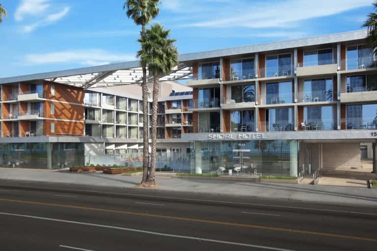 Modern Shore Hotel exterior with multi-story building, palm trees, and street-level entrance