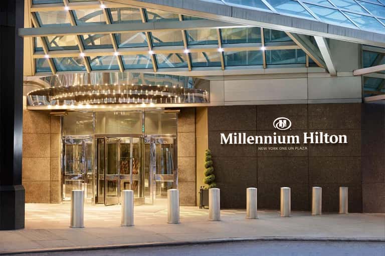 Millennium Hilton entrance at New York One UN Plaza with glass doors, dark signage, and bollard posts.