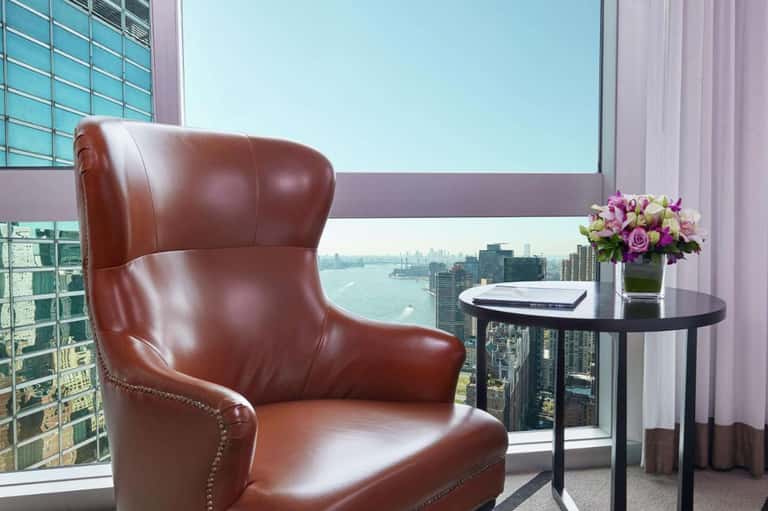 Modern leather armchair with city skyline view through floor-to-ceiling windows