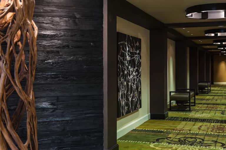 Modern hotel hallway with dark wood walls and contemporary artwork
