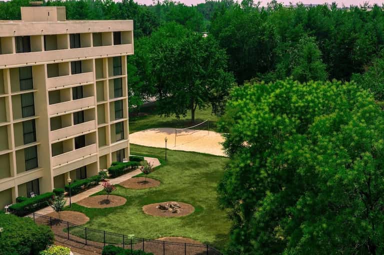 Multi-story residential building overlooking green landscape and trees