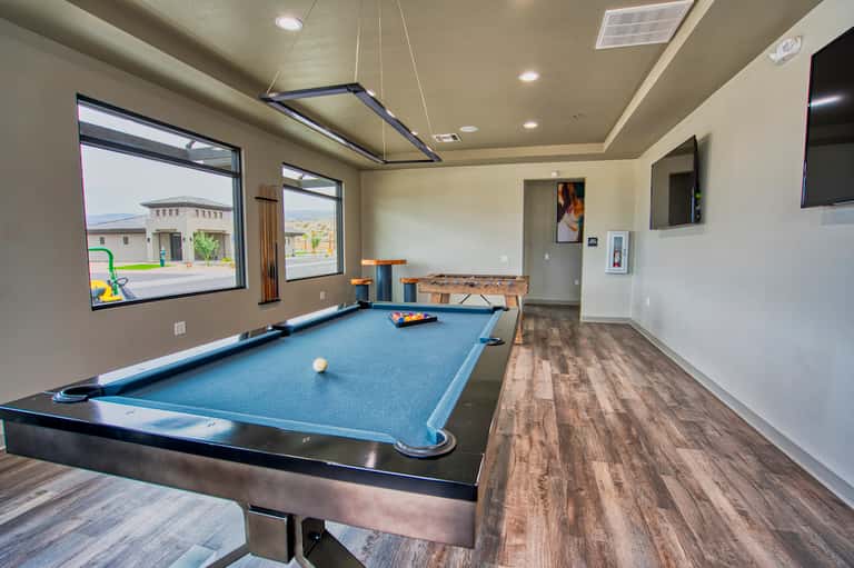 Game room with pool table, foosball table, and windows overlooking resort grounds