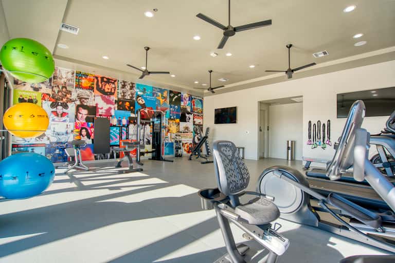 Bright modern fitness center with exercise equipment, motivational wall art, and natural lighting