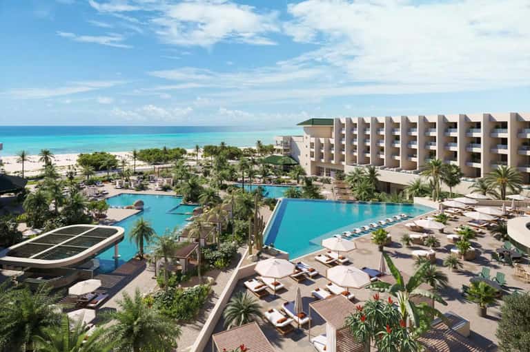 All-inclusive beachfront resort with multiple pools, palm trees, and turquoise ocean