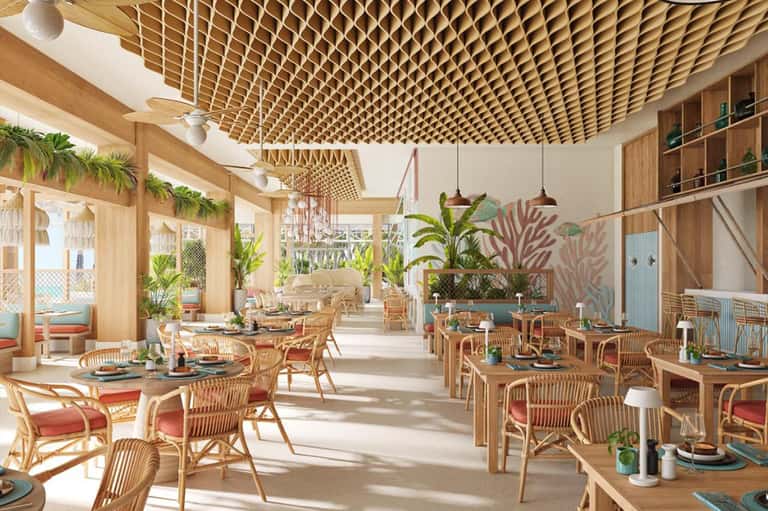 Bright tropical restaurant interior with wooden lattice ceiling, rattan chairs, and lush green plants