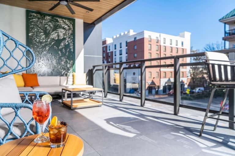 Rooftop terrace lounge with sofa, cocktails, city views, and modern furniture