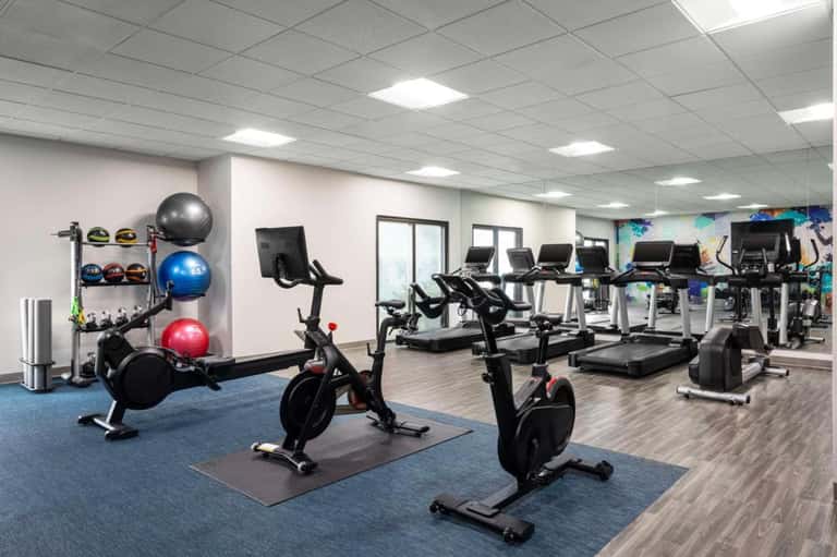 Fitness center with exercise bikes, treadmills, colorful exercise balls, and modern equipment