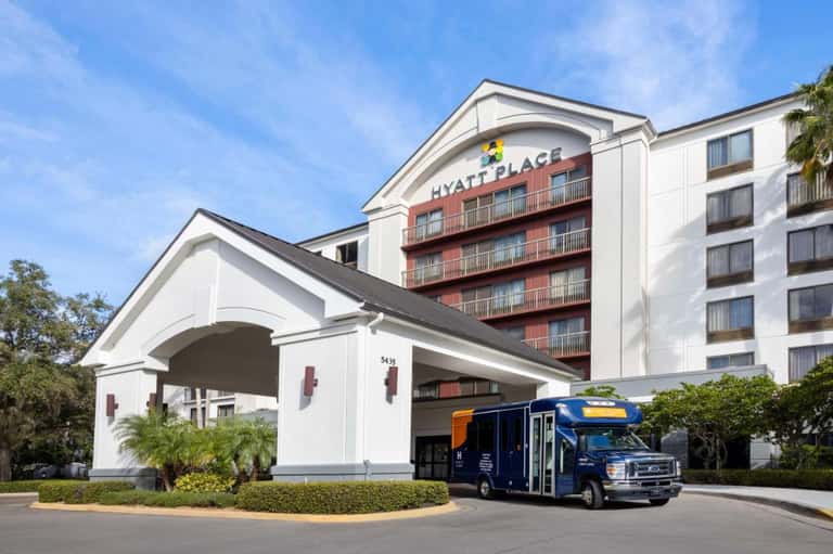 Hyatt Place hotel exterior with white portico entrance and multi-story residential building