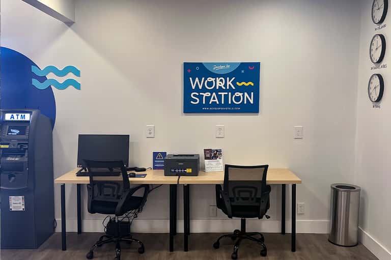 Hotel work station with desk, computer, printer, ATM, and workspace signage