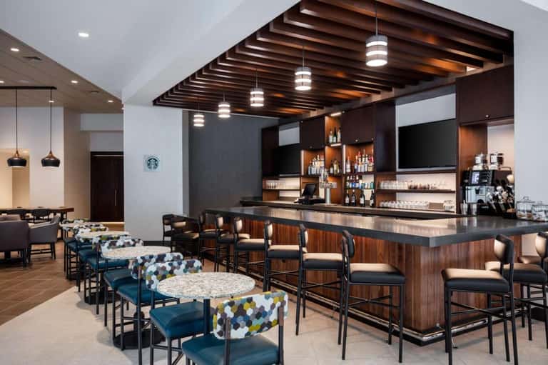 Modern resort bar and lounge with wood ceiling, dark wood bar counter