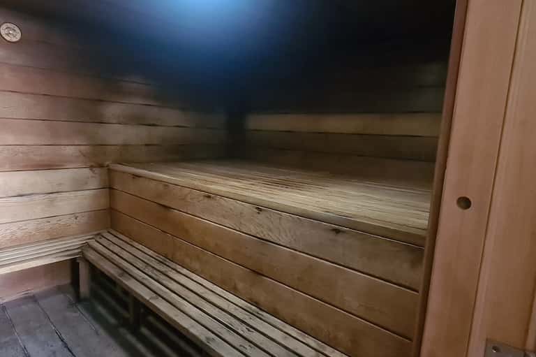 Interior view of wooden sauna with tiered benches and dim lighting