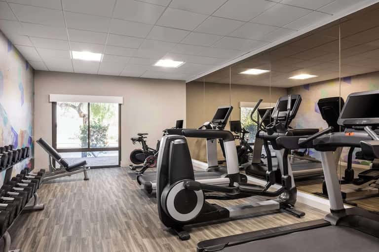 Fitness center with cardio equipment, exercise bikes, treadmills, and large windows