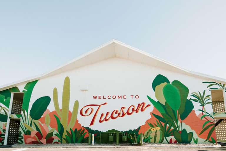 Welcome to Tucson mural on tent structure with desert plant illustrations in vibrant colors