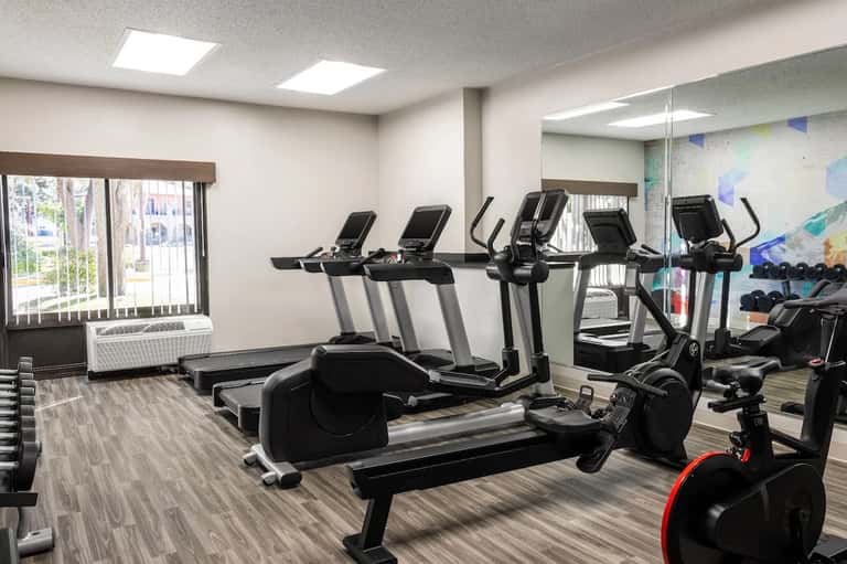 Fitness center with cardio equipment, treadmills, exercise bikes, and natural window lighting