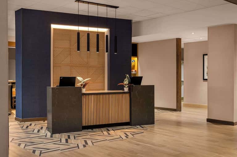 Contemporary hotel reception desk with wooden accent wall and blue panel