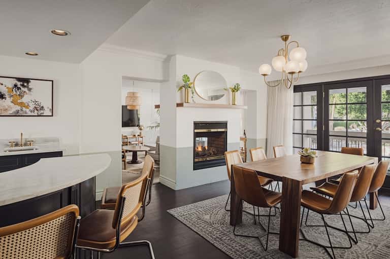 Upscale open-concept kitchen and dining room with fireplace, wood dining table, and sliding glass doors